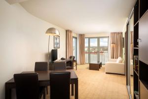 Habitación con mesa de comedor y sala de estar con vistas. en The Rilano Hotel Hamburg en Hamburgo