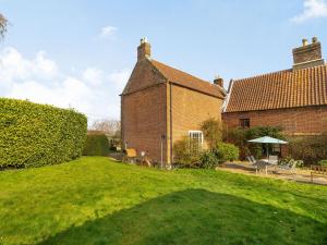 a large brick house with a yard with green grass at Hemblington Hall Arts And Leisure Ltd in South Walsham