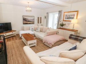 a living room with a couch and a tv at Riverside House in Amlwch