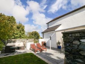 a patio with two chairs and a table at Riverside House in Amlwch