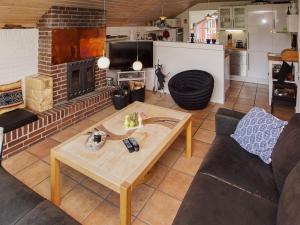 a living room with a table and a fireplace at 4 person holiday home in Hemmet in Hemmet