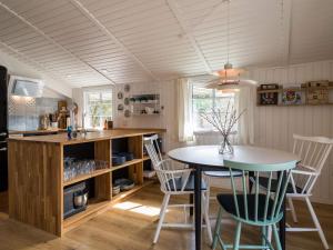 a kitchen and dining room with a table and chairs at Holiday home Fanø CLXX in Fanø