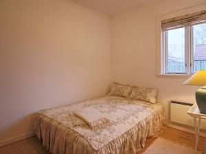 Habitación pequeña con cama y ventana en 4 person holiday home in Dronningm lle, en Dronningmølle