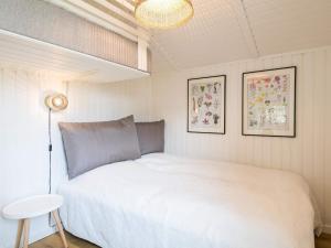 a bedroom with a large white bed and a lamp at Holiday home Fanø CLXX in Fanø