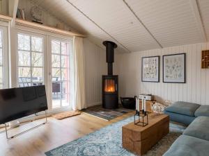a living room with a flat screen tv and a fireplace at Holiday home Fanø CLXX in Fanø