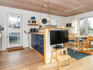 a kitchen and dining room with a tv and a table at 7 person holiday home in Ebeltoft in Ebeltoft