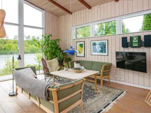 a living room with a table and chairs and a tv at 6 person holiday home in Bryrup in Bryrup