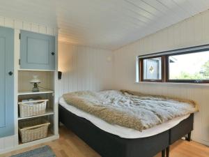 una camera con un letto in una stanza con una finestra di Holiday home Fanø CLXXVI a Fanø