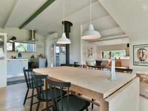 una cucina e una sala da pranzo con tavolo e sedie in legno di Holiday home Fanø CLXXVI a Fanø