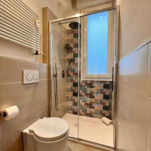 uma casa de banho com um chuveiro, um WC e uma janela. em LUCE em Bolonha