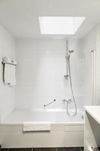 a white bathroom with a shower and a tub at Zimmerhof Hotel in Lier