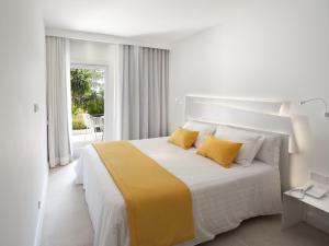 a bedroom with a large bed with yellow pillows at Paraíso de los Pinos in Sant Francesc Xavier