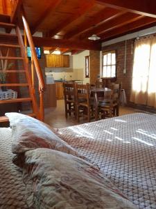 a bedroom with a bed and a kitchen with a table at Cabaña Balcón Serrano in Cortaderas