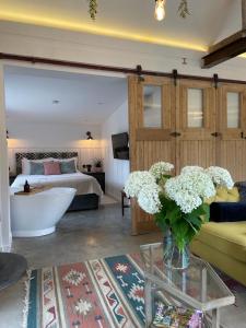 Luxury Barn with Hot Tub, Spa Treatments, Private Dining في Little Budworth: غرفة معيشة مع سرير و إناء من الزهور