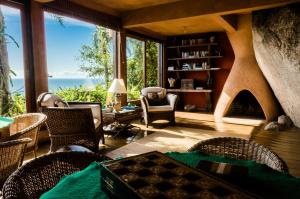 a living room with a fireplace and a table and chairs at Solar Mirador Exclusive Resort e SPA in Praia do Rosa