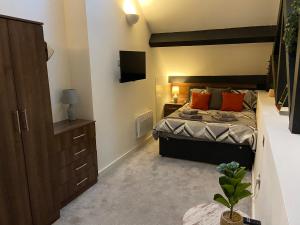 1 dormitorio con 1 cama con almohadas de color naranja en Cosy 2 Bed Duplex City Apartment, en Bradford