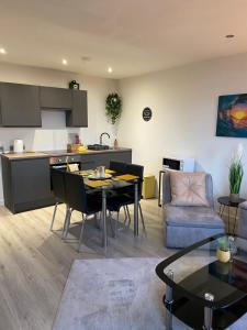 a kitchen and a living room with a table and chairs at Cosy 2 Bed Duplex City Apartment in Bradford
