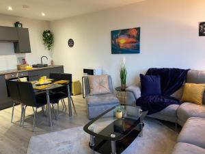 sala de estar con sofá y mesa en Cosy 2 Bed Duplex City Apartment en Bradford