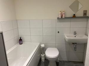 a white bathroom with a toilet and a sink at Cosy 2 Bed Duplex City Apartment in Bradford