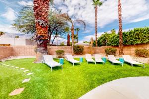 een groep stoelen in een tuin met palmbomen bij Sonoran Stunner Permit# 5058 in Palm Springs