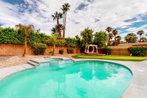 een zwembad in een tuin met palmbomen bij Sonoran Stunner Permit# 5058 in Palm Springs