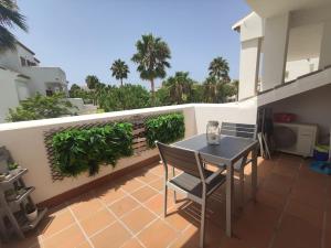 d'une terrasse avec une table et des chaises sur un balcon. dans l'établissement Precioso apartamento a 700 m del mar, à Chiclana de la Frontera