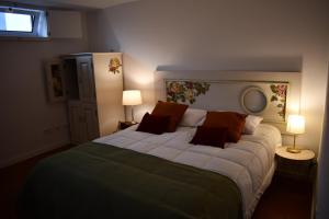 a bedroom with a large bed with two lamps at Casa de Diana in Évora
