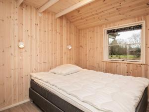 een bed in een houten kamer met een raam bij Holiday home Fjerritslev XXVII in Fjerritslev