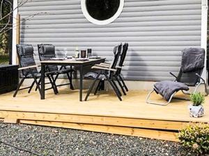 a wooden deck with a table and chairs at 4 person holiday home in L DDEK PINGE in Löddeköpinge