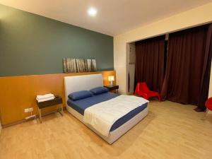 a bedroom with a bed and a red chair at Stylish Romantic Couples Getaway at KL City 1419 in Kuala Lumpur