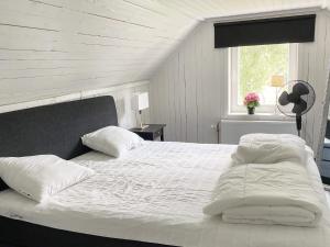 Una cama con sábanas blancas y almohadas en un dormitorio en Holiday home KARLSKRONA III en Karlskrona