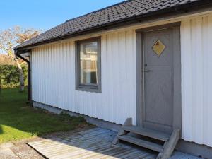 a small white building with a door and a bench at 2 person holiday home in Falkenberg in Falkenberg