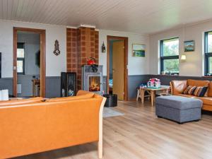 a living room with orange furniture and a fireplace at 8 person holiday home in R m in Lakolk