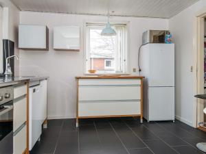 eine Küche mit einem Kühlschrank und einem Fenster in der Unterkunft 6 person holiday home in Ringk bing in Ringkøbing