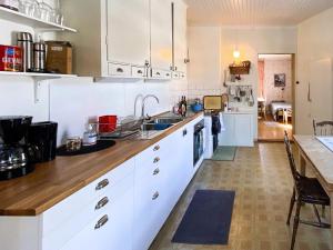 a kitchen with white cabinets and a wooden counter top at Holiday home LYCKSELE in Lycksele