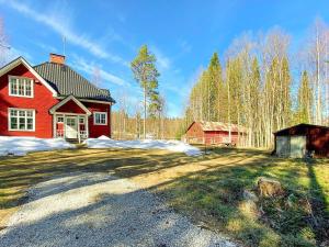 a red house with a barn in the yard at Holiday home LYCKSELE in Lycksele