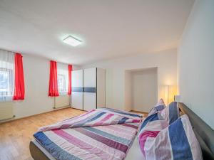 a bedroom with two beds and red curtains at Apartment am Lift Top 1 in Hopfgarten im Brixental