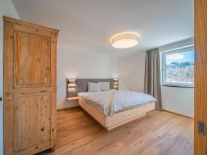 ein Schlafzimmer mit einem Bett und einem großen Fenster in der Unterkunft Apartement am Lift XL in Hopfgarten im Brixental