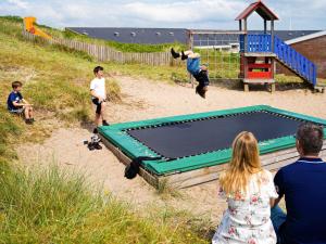 a group of children playing on a trampoline on the beach at 6 person holiday home on a holiday park in Ringk bing in Ringkøbing