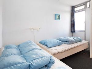 twee bedden in een kamer met blauwe kussens bij 6 person holiday home on a holiday park in Ringk bing in Ringkøbing