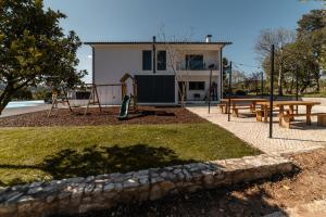 un parc avec une aire de jeux dotée de bancs et un bâtiment dans l'établissement Granja da Cabrita, à Coimbra