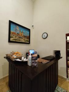 una scrivania in una stanza con un orologio sul muro di MELISA HOSTAL a Campeche