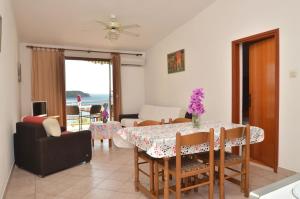 uma sala de jantar e sala de estar com mesa e cadeiras em Apartments by the sea Prizba, Korcula - 9276 em Prizba