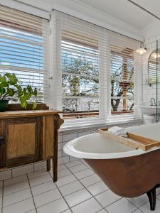 a large bathroom with a tub and windows at Annesley House in Portland