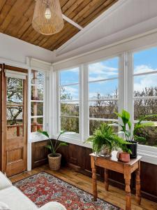 een kamer met ramen en een tafel met planten bij Annesley House in Portland +69 foto's