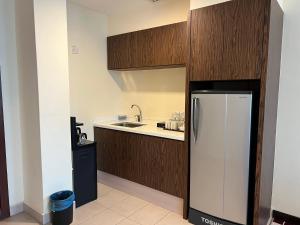 a kitchen with a refrigerator and a sink at SSL Traders Hotel in Taiping