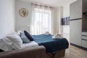米蘭的住宿－Milano City Apartments - Parking and Comfort - Spacious Apt up to 8 Pax，卧室配有一张挂在墙上的带时钟的床