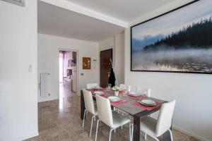 米蘭的住宿－Milano City Apartments - Parking and Comfort - Spacious Apt up to 8 Pax，一间带桌子和白色椅子的用餐室
