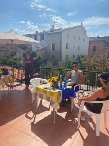 eine Gruppe von Menschen, die auf einer Terrasse am Tisch sitzen in der Unterkunft Albergue Estrella Guia Solo Peregrinos in Puente la Reina