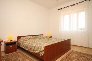 Ένα ή περισσότερα κρεβάτια σε δωμάτιο στο Family friendly seaside apartments Ugljan - 828